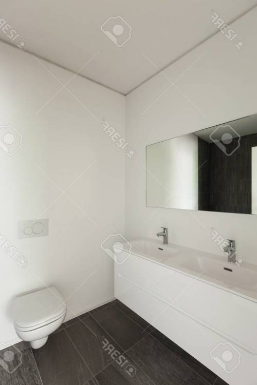 Salle de bains moderne ensoleillée de l'appartement contemporain avec  regarder à travers la fenêtre de toit