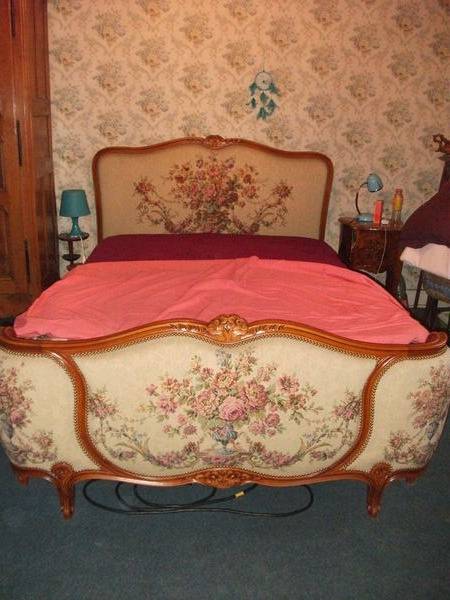 Livre sur la couverture sur le lit en bois de rose contre le mur gris avec le bâti dans l'intérieur de la chambre à coucher confortable — Image de